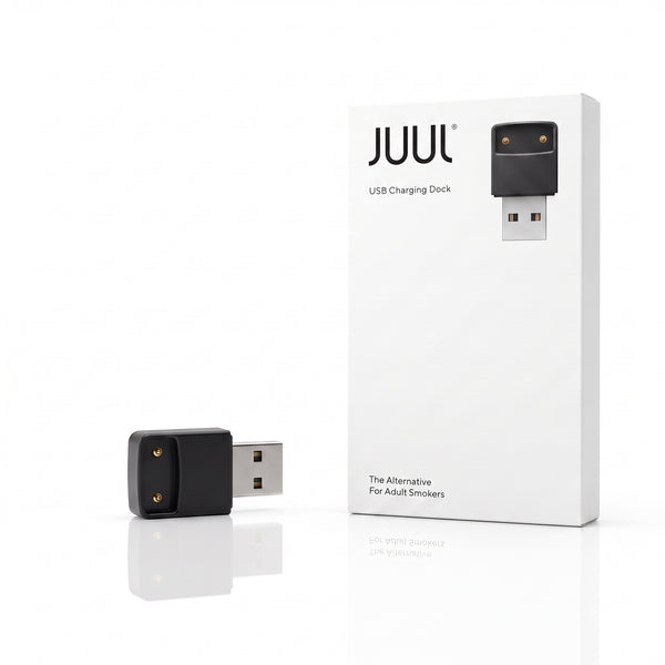 A black USB charging dock shown next to its white retail box on a clean white background. The box features the JUUL brand name and a graphic of the charging dock.